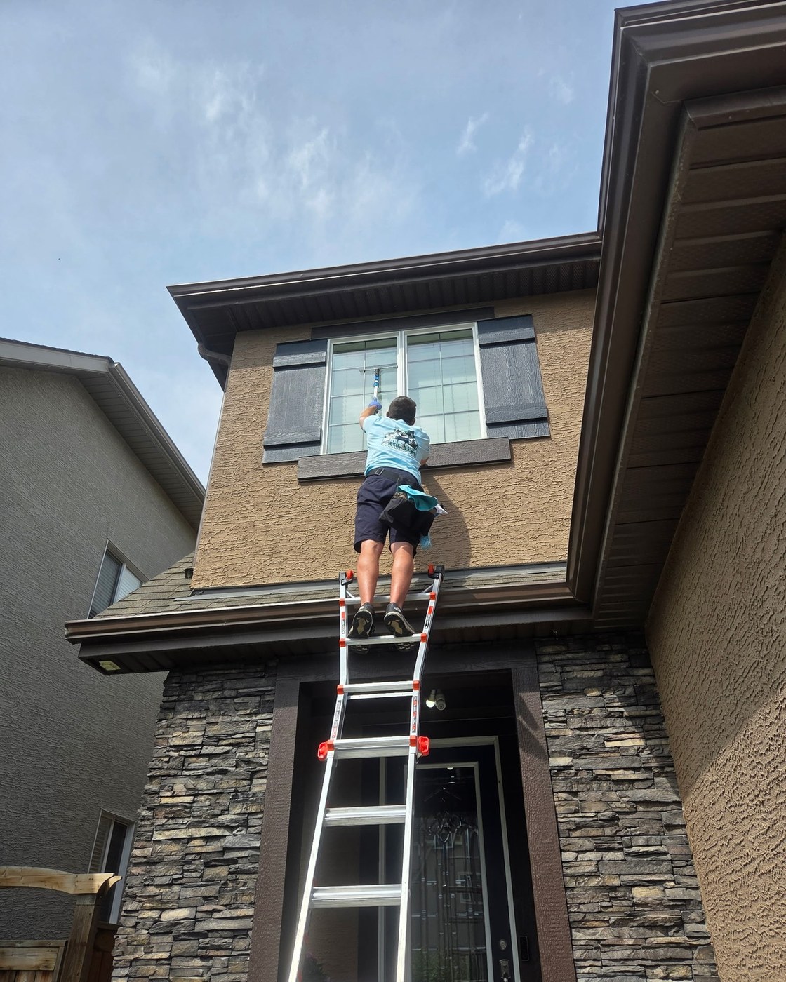 Fresh Cleaning YYC window cleaner on a ladder in Calgary